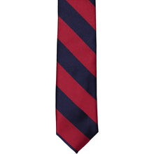 Load image into Gallery viewer, The front of a crimson red and navy blue striped skinny tie, laid out flat