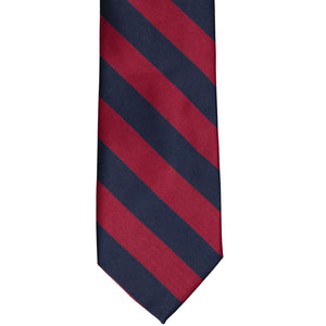 The front of a crimson red and navy blue striped tie, laid out flat