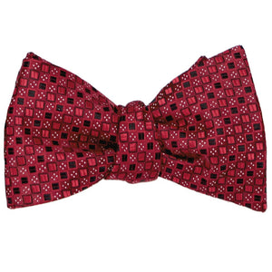A crimson red self-tie bow tie, tied, in a square pattern