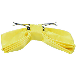 A daffodil yellow clip-on bow tie, opened to show how the clips work