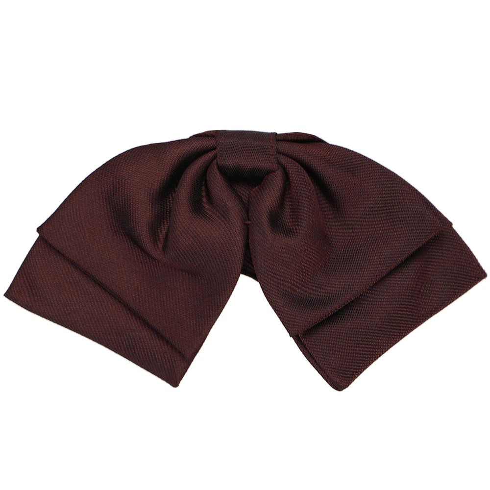 A dark burgundy floppy bow tie, close up to show texture and matte finish