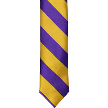 Load image into Gallery viewer, The front of a dark purple and gold striped skinny tie, laid out flat