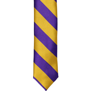 The front of a dark purple and gold striped skinny tie, laid out flat