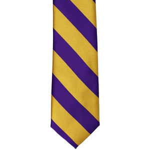 The front of a dark purple and gold striped tie, laid out flat