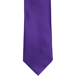 The front of a dark purple solid tie, laid out flat