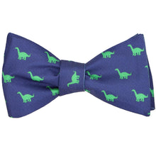 Load image into Gallery viewer, A tied self tie bow tie in dark blue with an all over brontosaurus pattern
