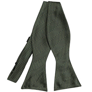 Front view of an untied self-tie bow tie in a dark green and sage green chevron pattern