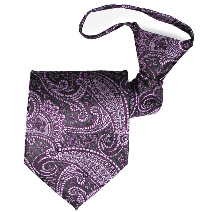 A zipper tie in an eggplant purple paisley pattern, rolled to show the front and knot