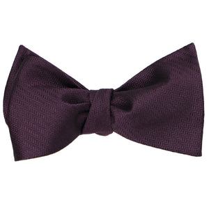 A tied eggplant purple self-tie bow tie
