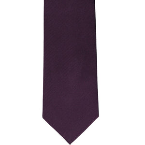 The front of an eggplant purple herringbone tie, laid out flat