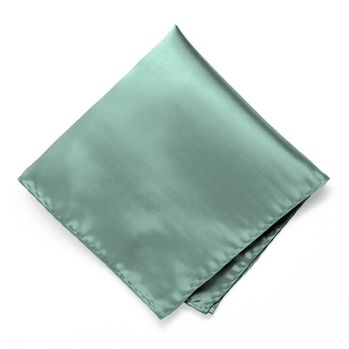 A solid pocket square in eucalyptus green hue, folded into a diamond