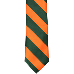 The front of an orange and dark green striped slim tie, laid out flat