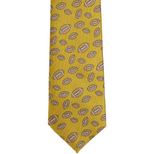 Load image into Gallery viewer, The front of a gold football pattern tie, laid flat
