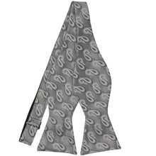 Load image into Gallery viewer, A gray paisley bow tie in a self-tie style. Displayed untied