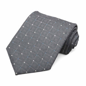 A dark gray necktie with tiny white and blue dots, rolled to show texture and pattern