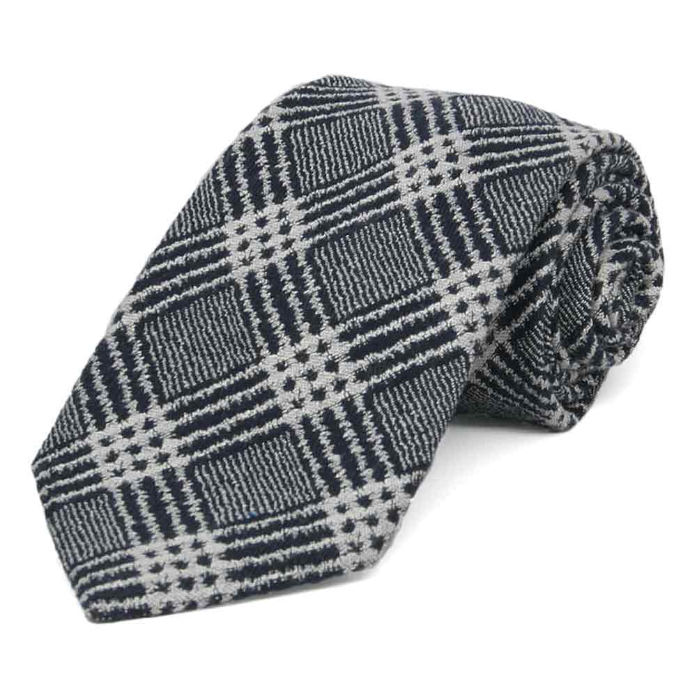 A highly textured black and gray plaid wool necktie, rolled to show details close up