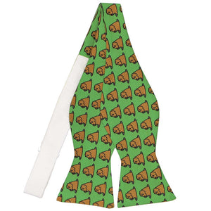 An untied bright green self-tie bow tie with groundhogs popping up all over