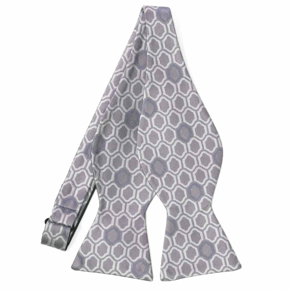 An untied tan and gray self-tie bow tie with a hexagonal pattern