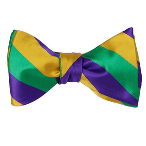 A kelly green, gold and dark purple self-tie bow tie, tied