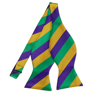 An untied self-tie bow tie in dark purple, kelly green and gold