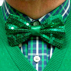 Man wearing a green sequin bow tie with a matching green sweater and plaid shirt