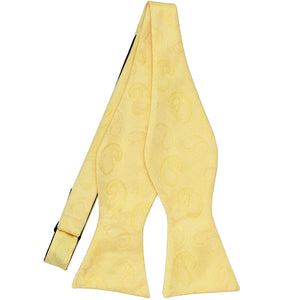 An untied light yellow self-tie bow tie in a paisley tone-on-tone pattern