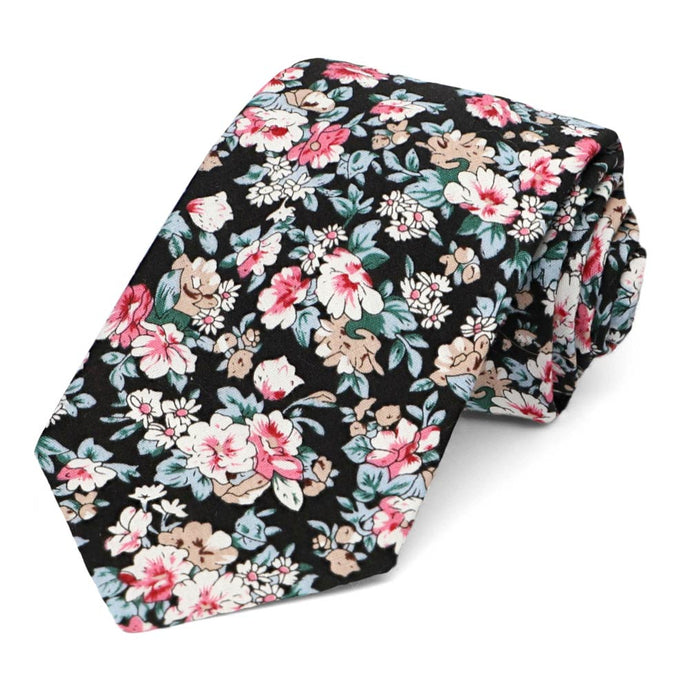 A black and tan floral tie, rolled to show tie tip