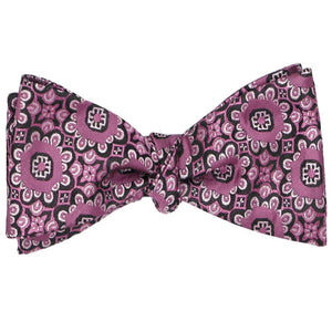 A tied self-tie bow tie in a deep magenta floral pattern
