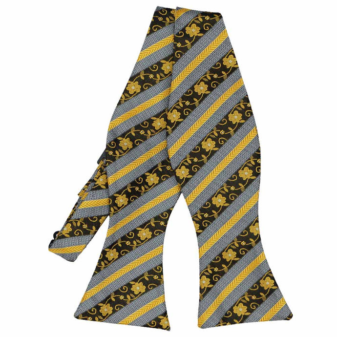 An untied self-tie bow tie in black and yellow floral stripes