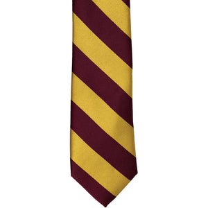 The front of a maroon and gold striped tie, laid out flat