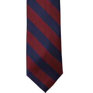 The front of a maroon and navy blue striped tie, laid out flat