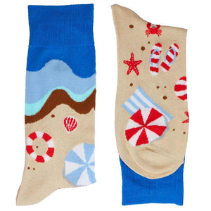 A folded pair of socks with a beach and water scene
