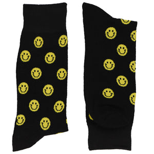 A folded pair of smiley face socks on a black background