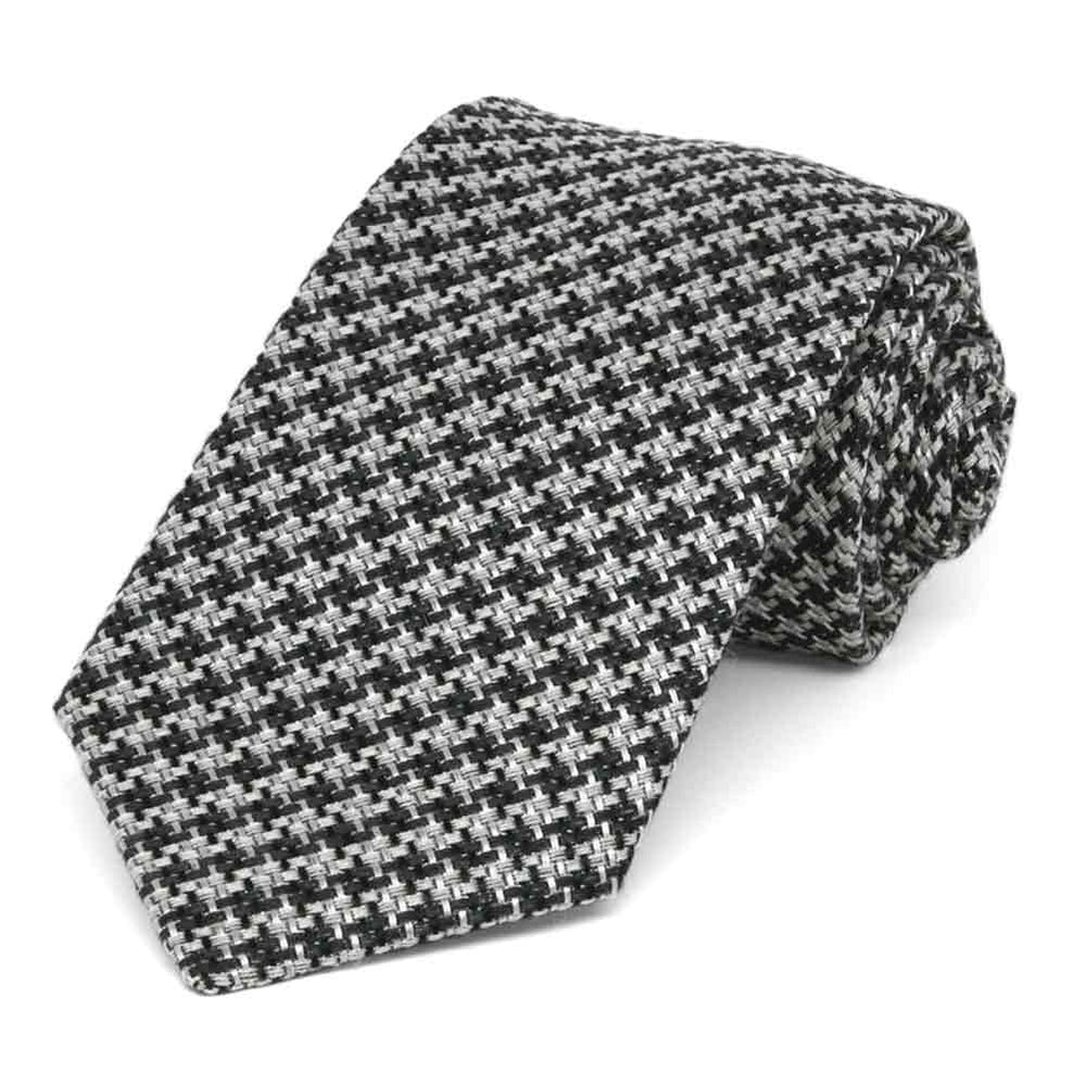 Black and white tweed necktie, rolled to show thick woven texture