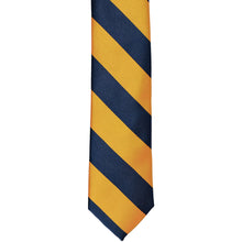 Load image into Gallery viewer, The front of a navy blue and gold bar striped skinny tie, laid out flat