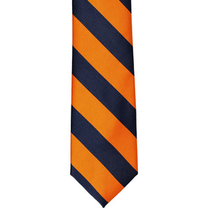The front of a navy blue and orange striped tie, laid out flat
