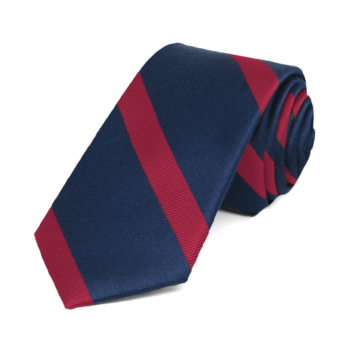 Navy blue and red striped skinny tie, rolled to show the texture of the stripes