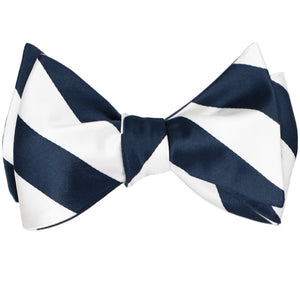 Navy blue and white striped self-tie bow tie, tied
