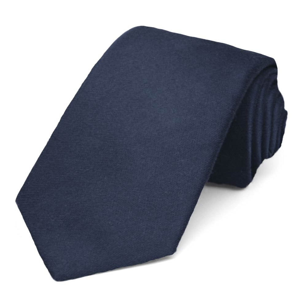 Narrow navy blue men's necktie rolled to show off the matte finish