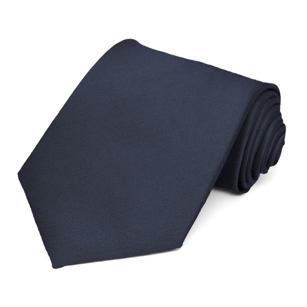 A solid navy blue necktie rolled to show the texture