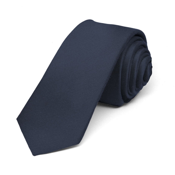 Skinny navy blue tie, rolled to show woven texture