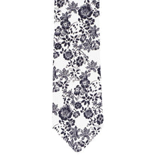 Load image into Gallery viewer, The front of a navy blue and white floral tie, laid flat
