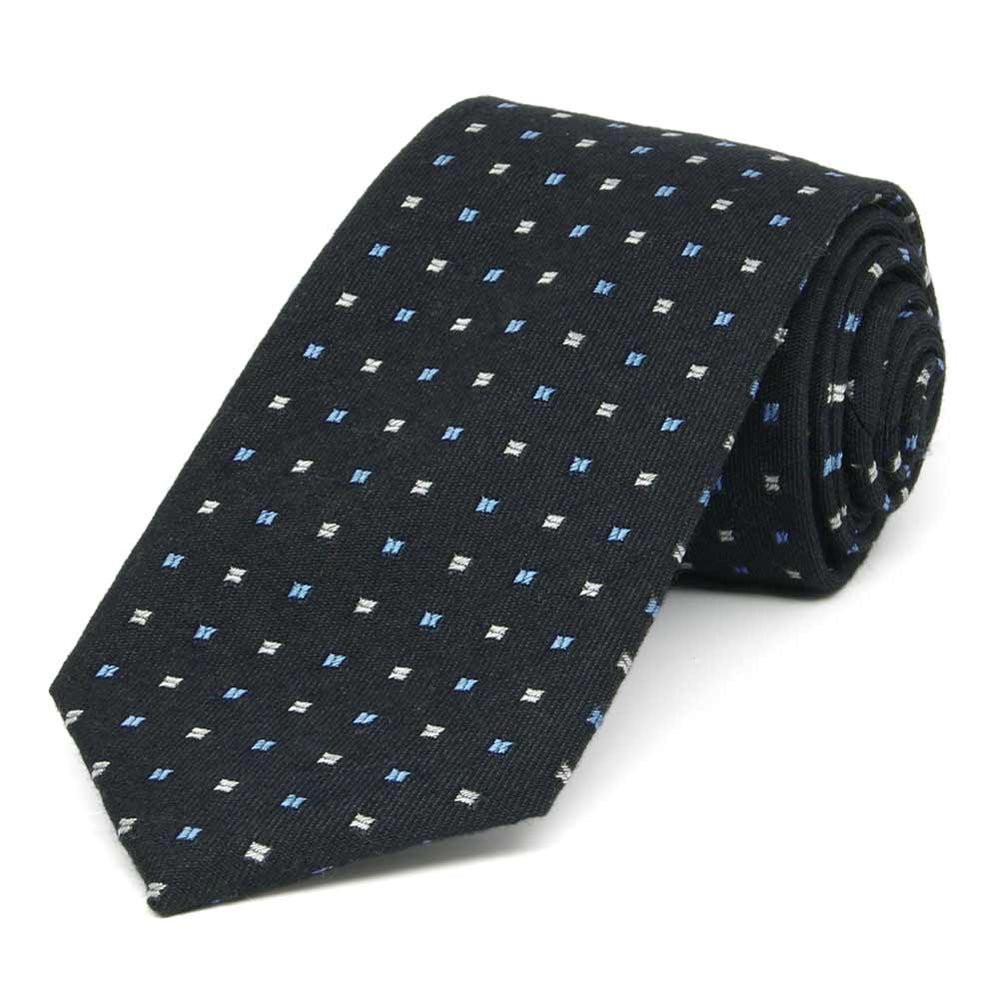 A navy blue necktie featuring small white and blue squares, rolled to show woven texture