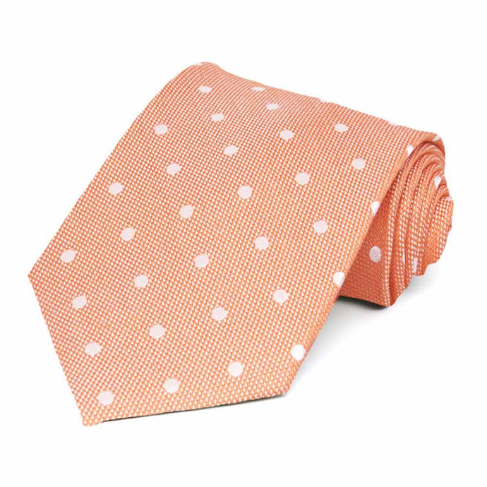 An orange and white polka dot necktie, rolled to show texture
