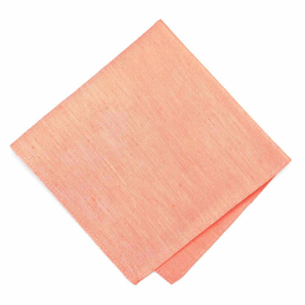 A folded soft orange pocket square with a linen texture