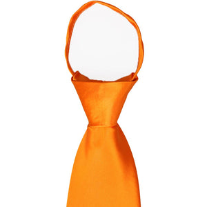 A closeup of the knot and collar on an orange zipper tie