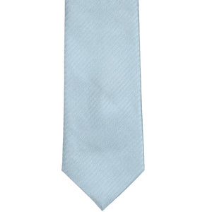 The front of a pale blue herringbone tie, laid out flat