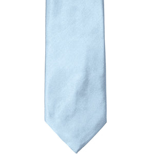 The front of a pale blue solid tie, laid out flat