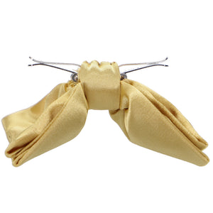 Side view of a pale gold clip-on bow tie