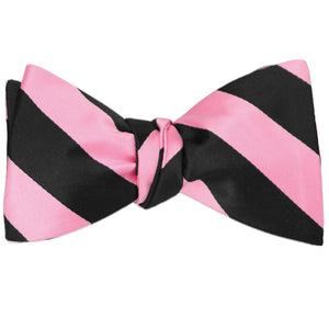 A pink and black striped self-tie bow tie, tied